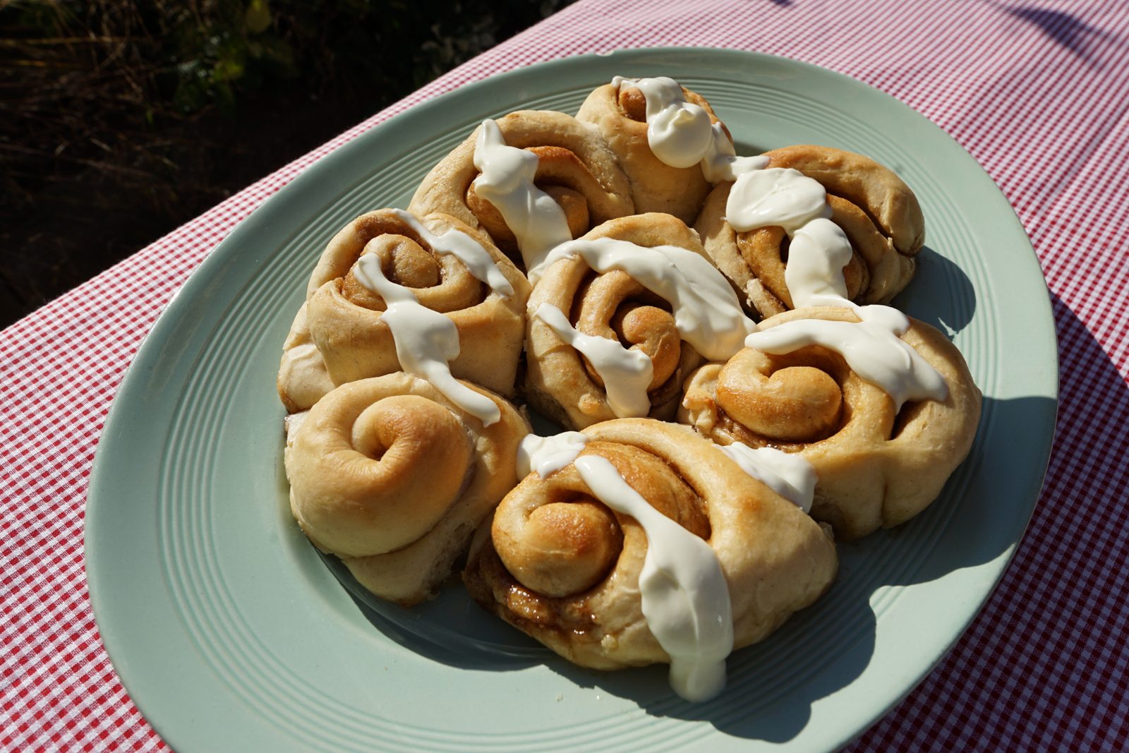 Iced cinnamon buns on a sage green plate