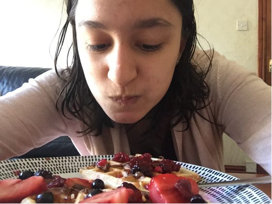 Zhahla leaning in over a plate of fresh fruit
